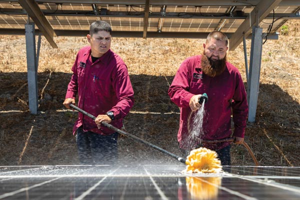 Gonzales City workers wash solar panels