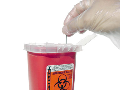 Sharps container with gloved hand putting a sharp in the container
