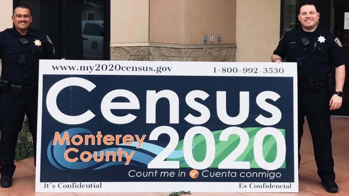 Complete your 2020 Census Photo: Two police officers holding a Census 2020 banner