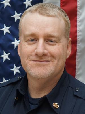 Fire Chief Muscio in front of American Flag